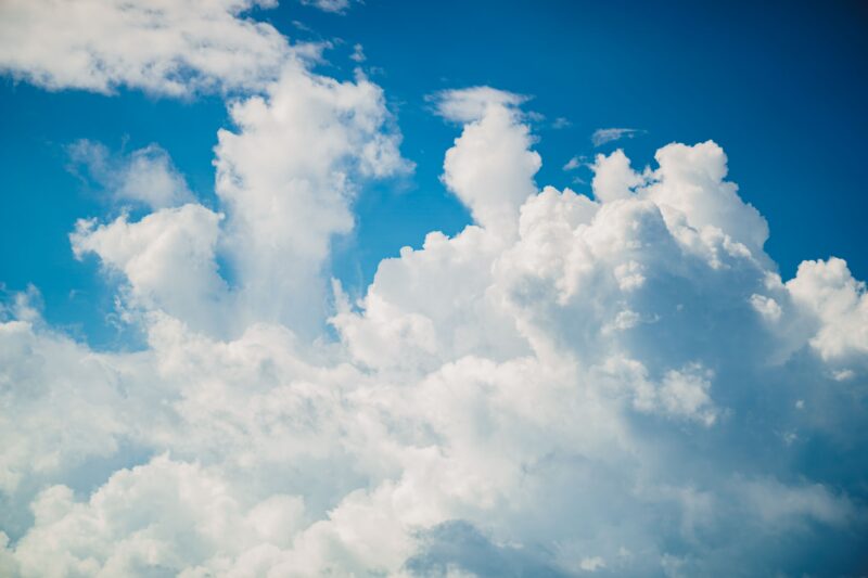 Vivid image of fluffy white clouds contrasting against a bright blue sky, perfect for serene outdoor themes.